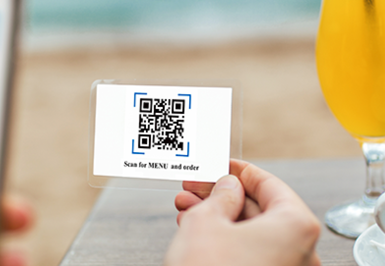 Women's hands are using smartphone to scan a qr code to view a menu.