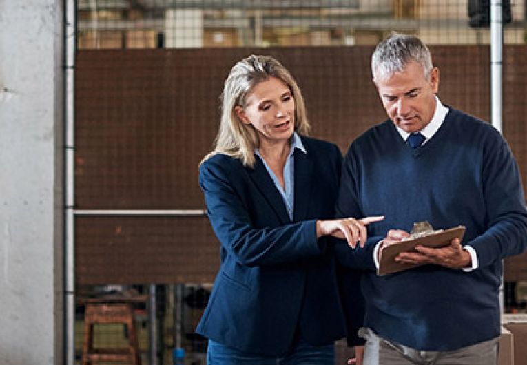 man and woman discussing something in a warehouse