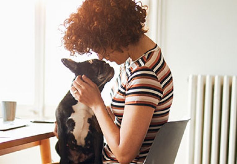 Woman holding dog at home office