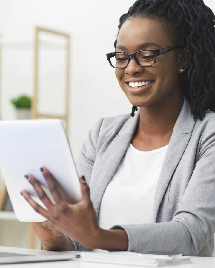 smiling woman looking at tablet