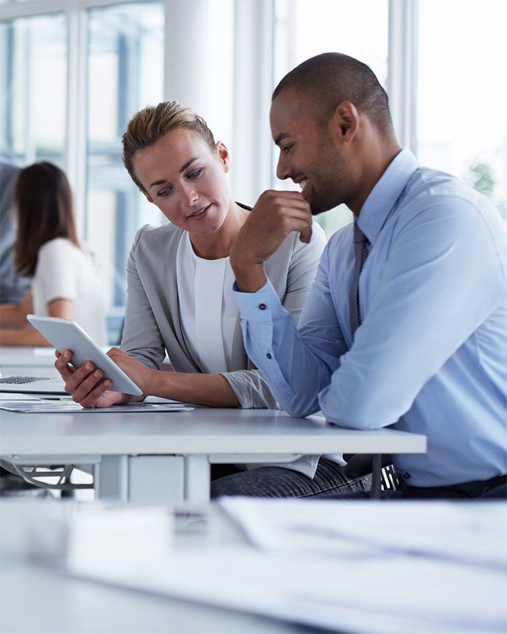 man and woman looking at a tablet