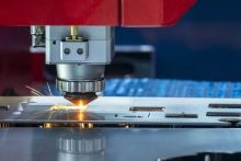 Laser cutting into steal to make a computer board.