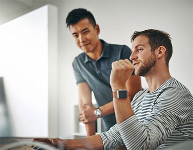 two men looking at a computer