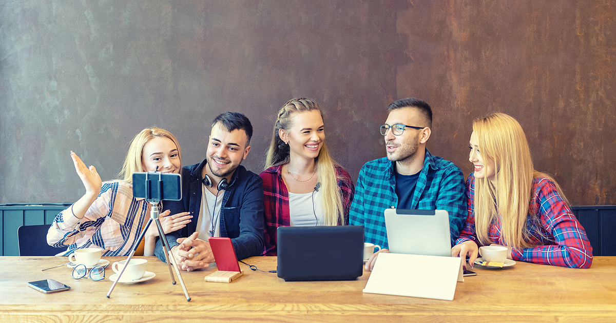 Five young men and women sharing content on streaming platform with digital web camera